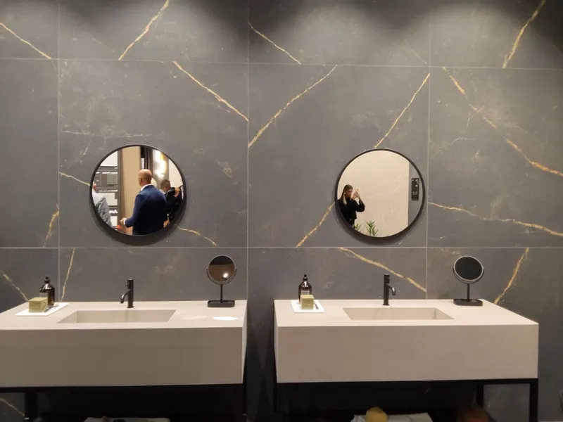 Lavabo monolitico in ceramica effetto marmo con venature continue dalla parete al piano d'appoggio